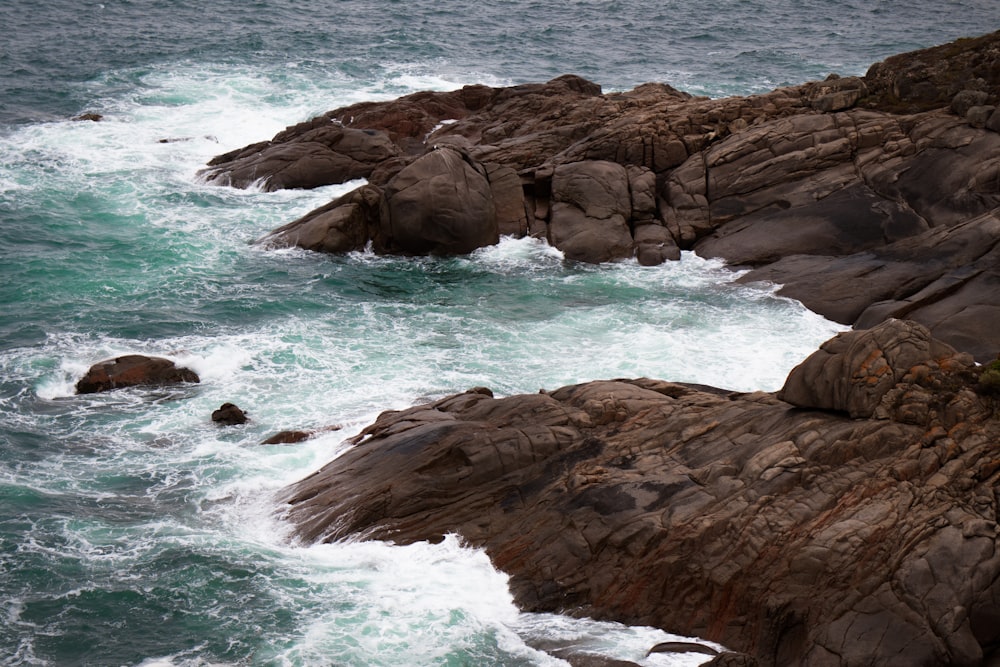 a couple of rocks sitting on top of a body of water