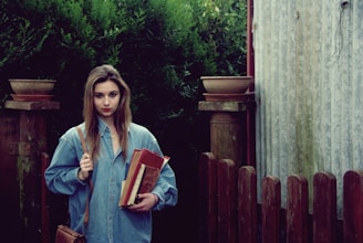 A happy international student holding books on an Australian university campus.