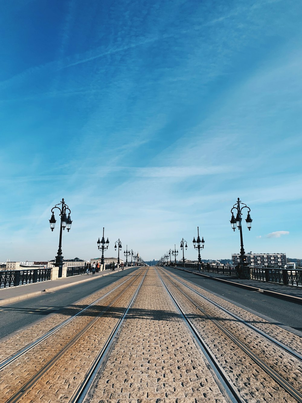 empty road between lamp posts during daytime