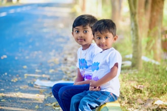 boy's sitting beside road