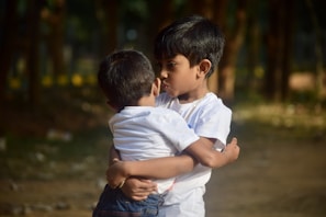 Two children hugging their plush guardian angels in a park.