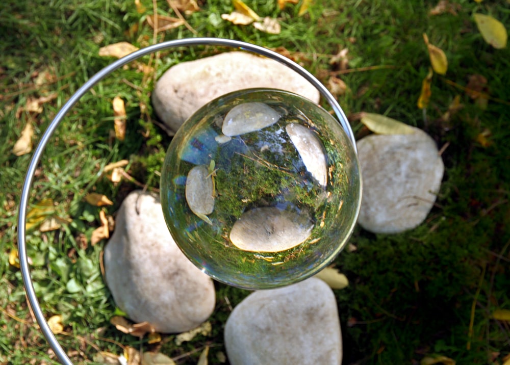 clear ball reflecting rocks and grass