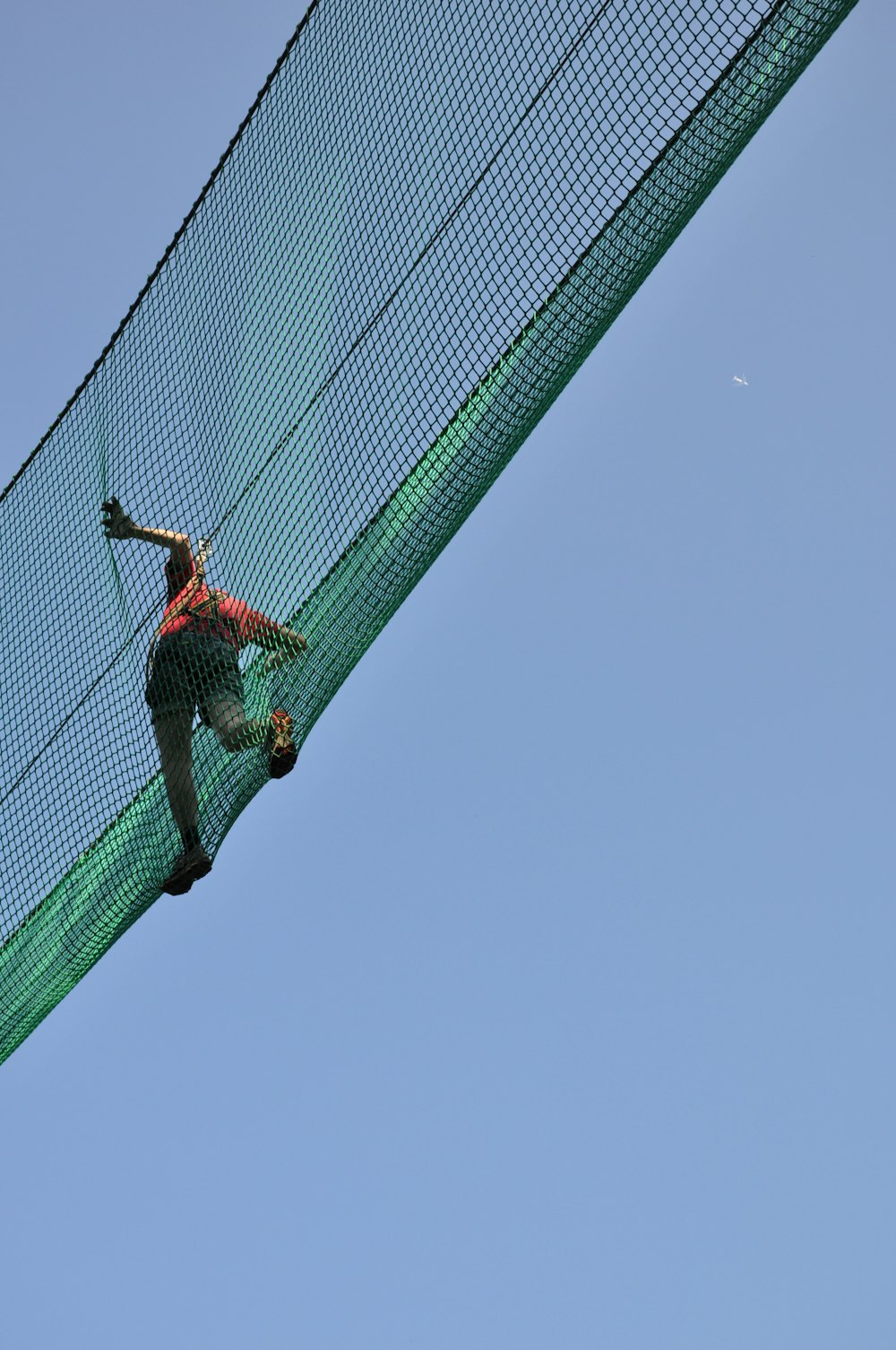 person crossing net bridge