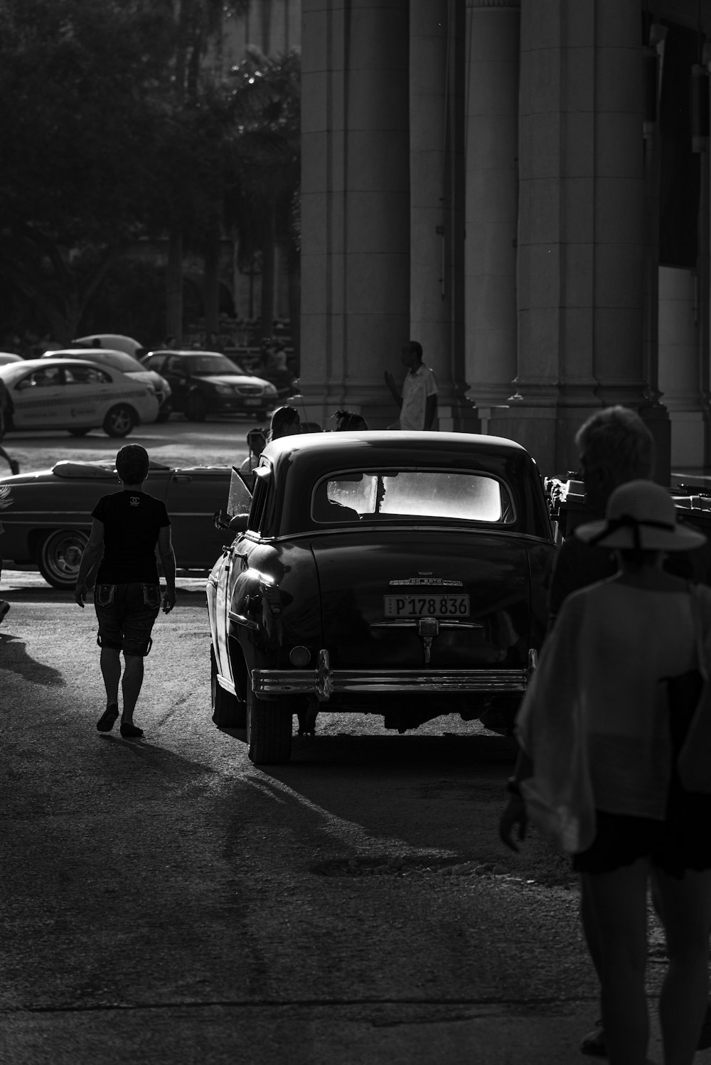 grayscale photo of vehicles and people on street