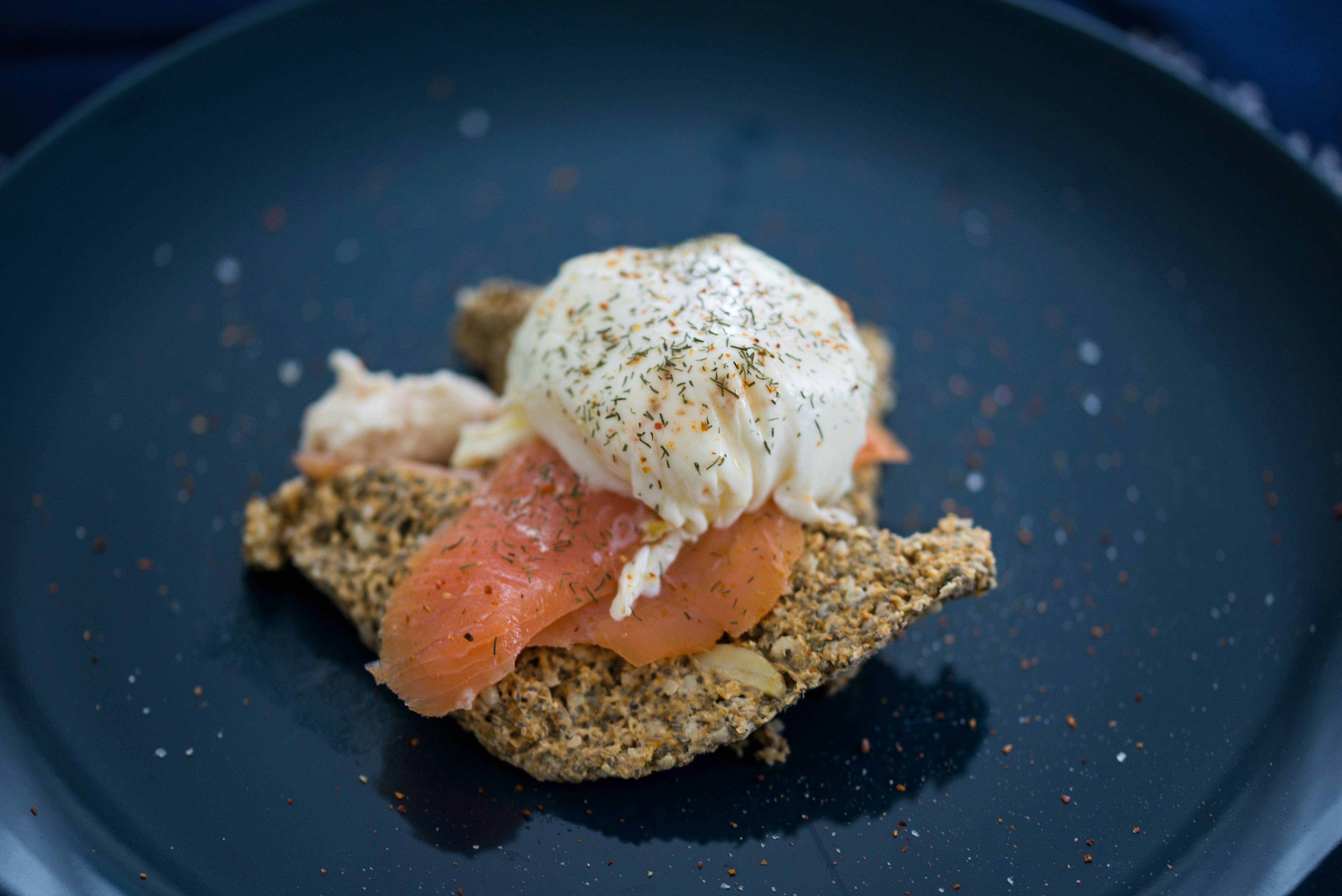 Poached egg on smoked salmon toast on a dark plate