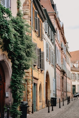A quiet cobblestone street in an old Portuguese town, lined with colorful houses.