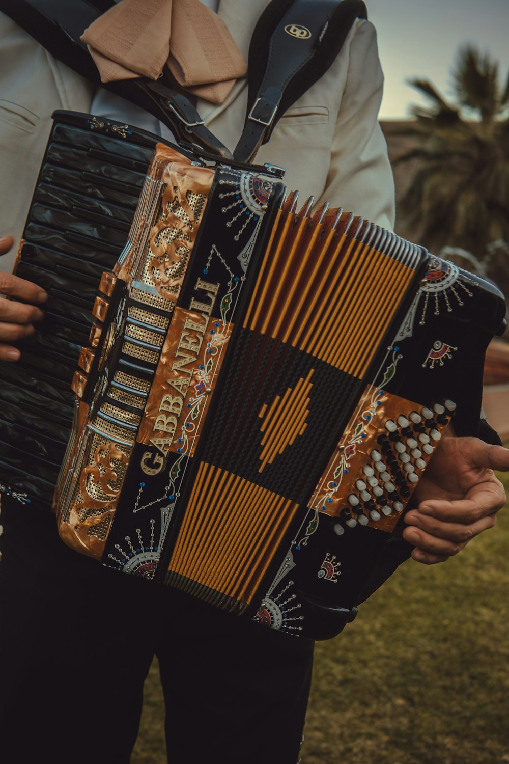 person wearing white jacket standing while playing accordion