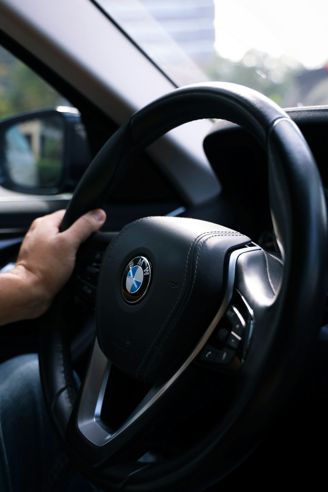 selective focus photography of black BMW steering wheel