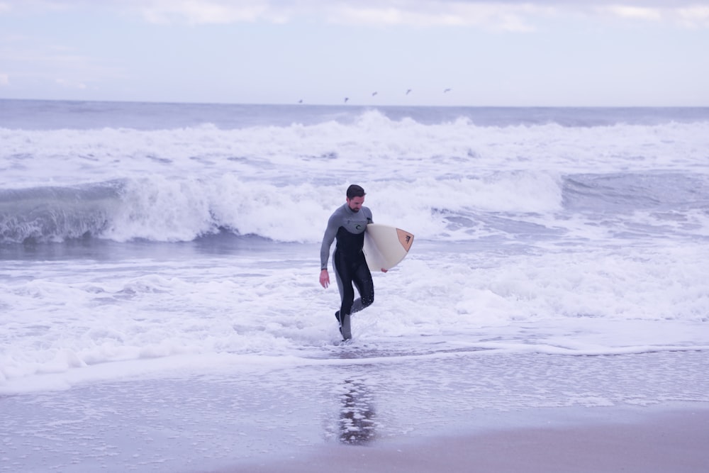 male surfer on shore during daytime