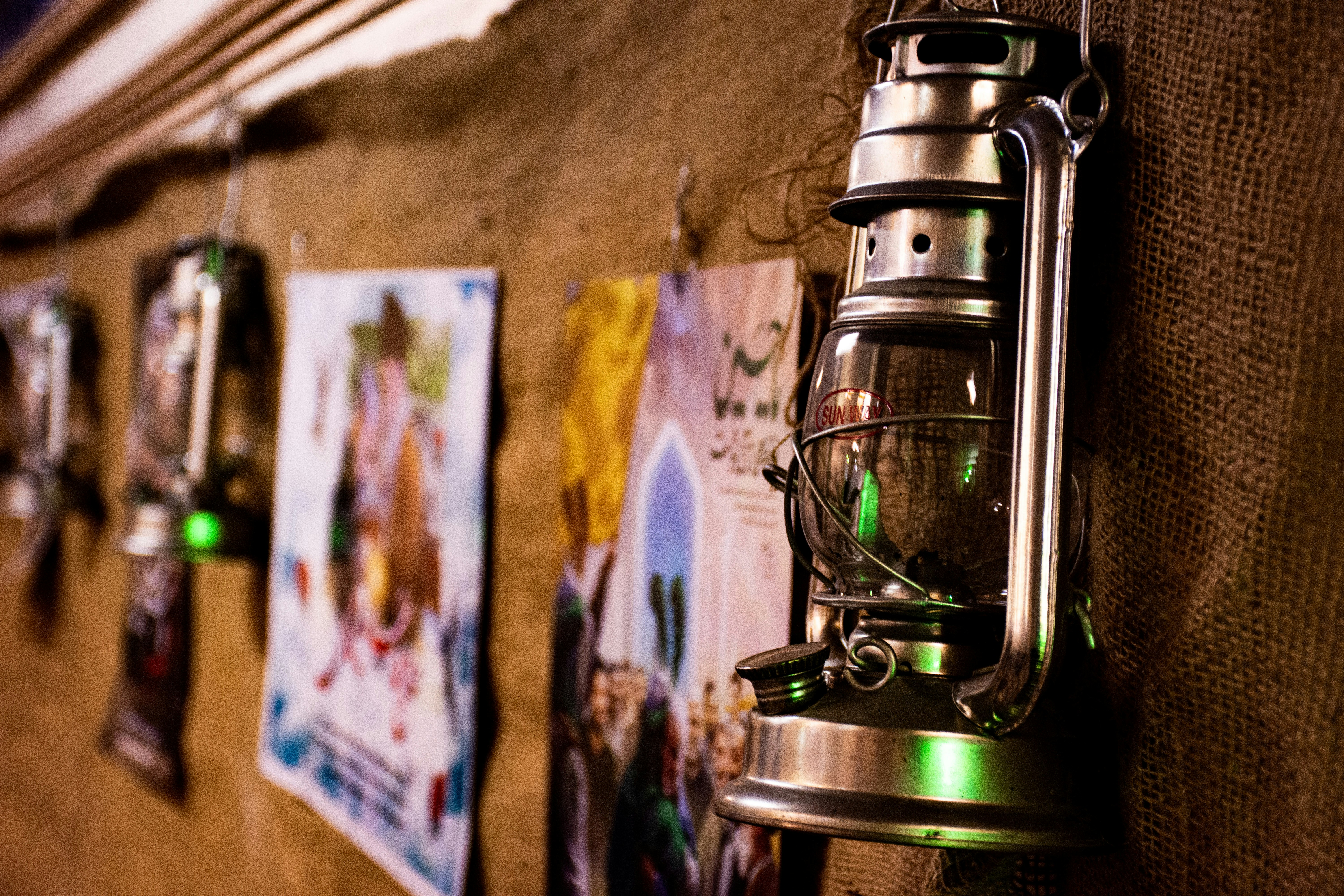 A hand switching on a powerful camping lantern in a dark tent