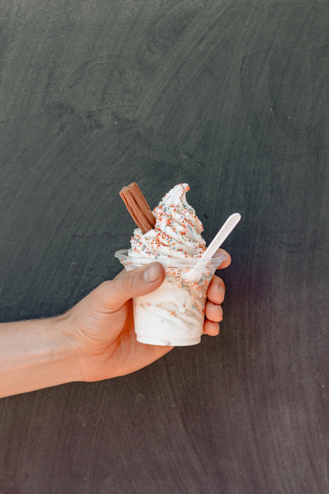 person holding ice cream with cinnamon and sprinkles