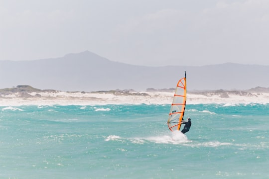 man riding on the orange and black boat in Struisbaai South Africa