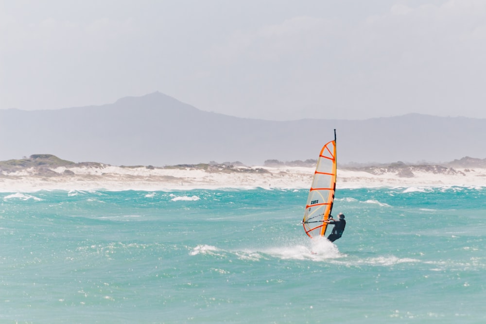 man riding on the orange and black boat