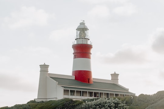 white and red lighthouse under white sky in Cape Agulhas, Lighthouse South Africa