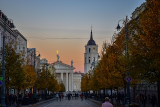a group of people walking down a street next to tall buildings