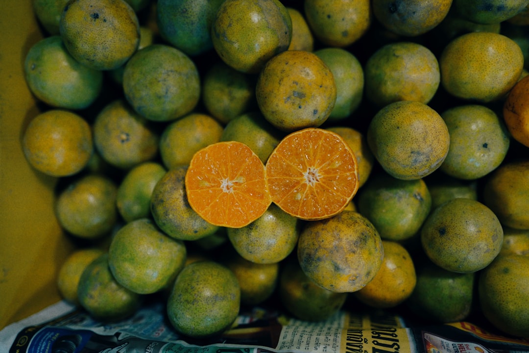 sliced orange on top of oranges in box