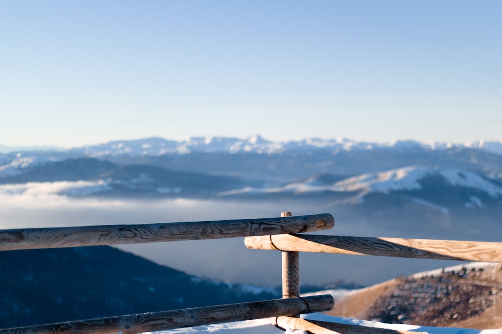 brown wooden railings viewing mountain under blue and white sky