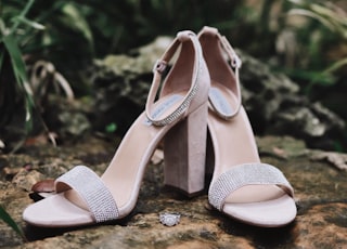 pair of silver open-toe ankle-strap heeled sandals on ground