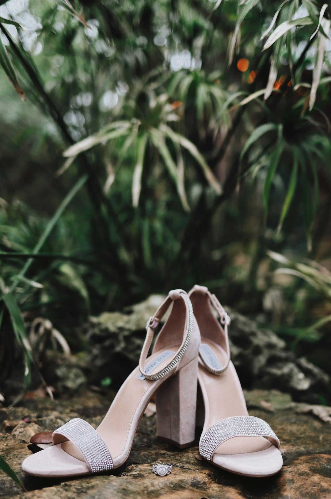 pair of silver open-toe ankle-strap heeled sandals on ground