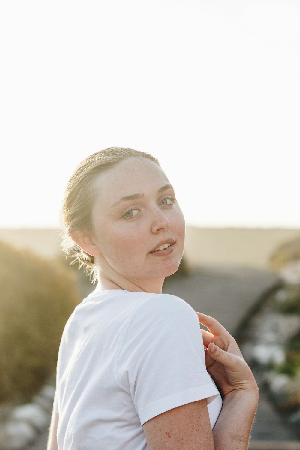 woman wearing white t-shirt standing while glancing her left side