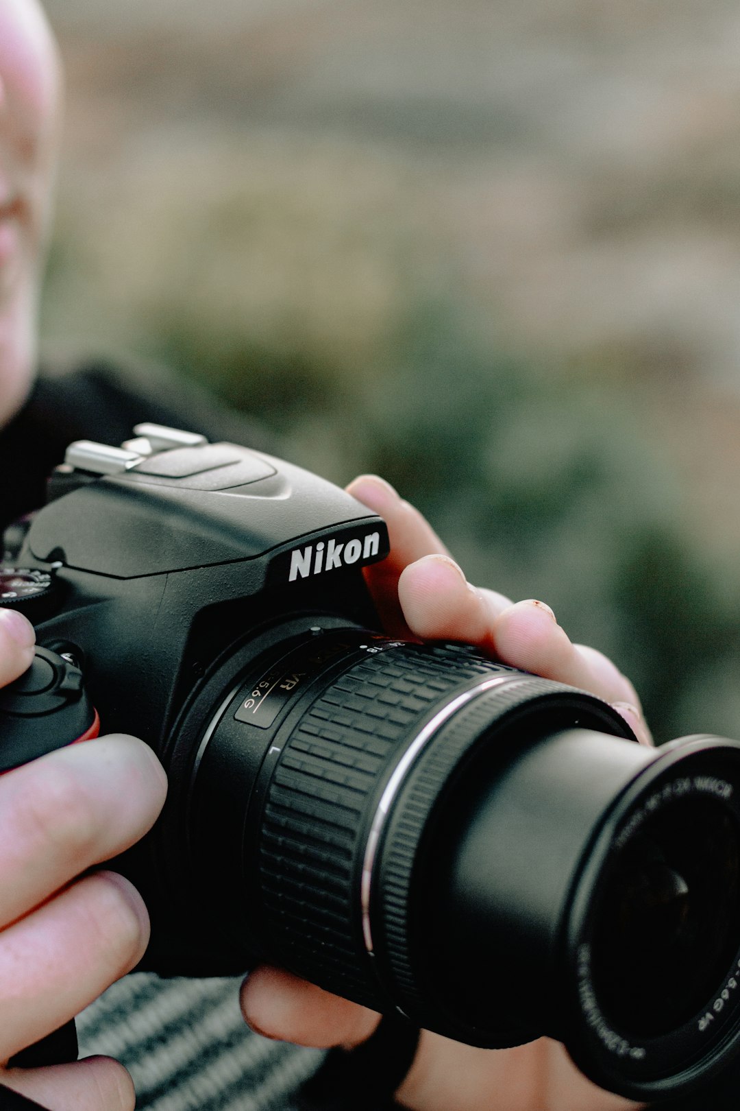 person holding black Nikon DSLR camera