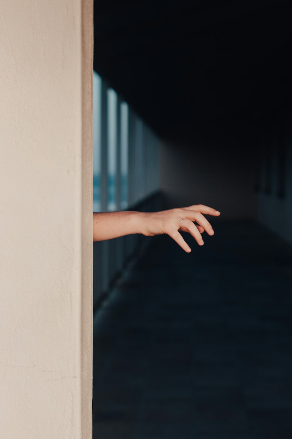 uma mão estendendo para fora de uma porta para um corredor