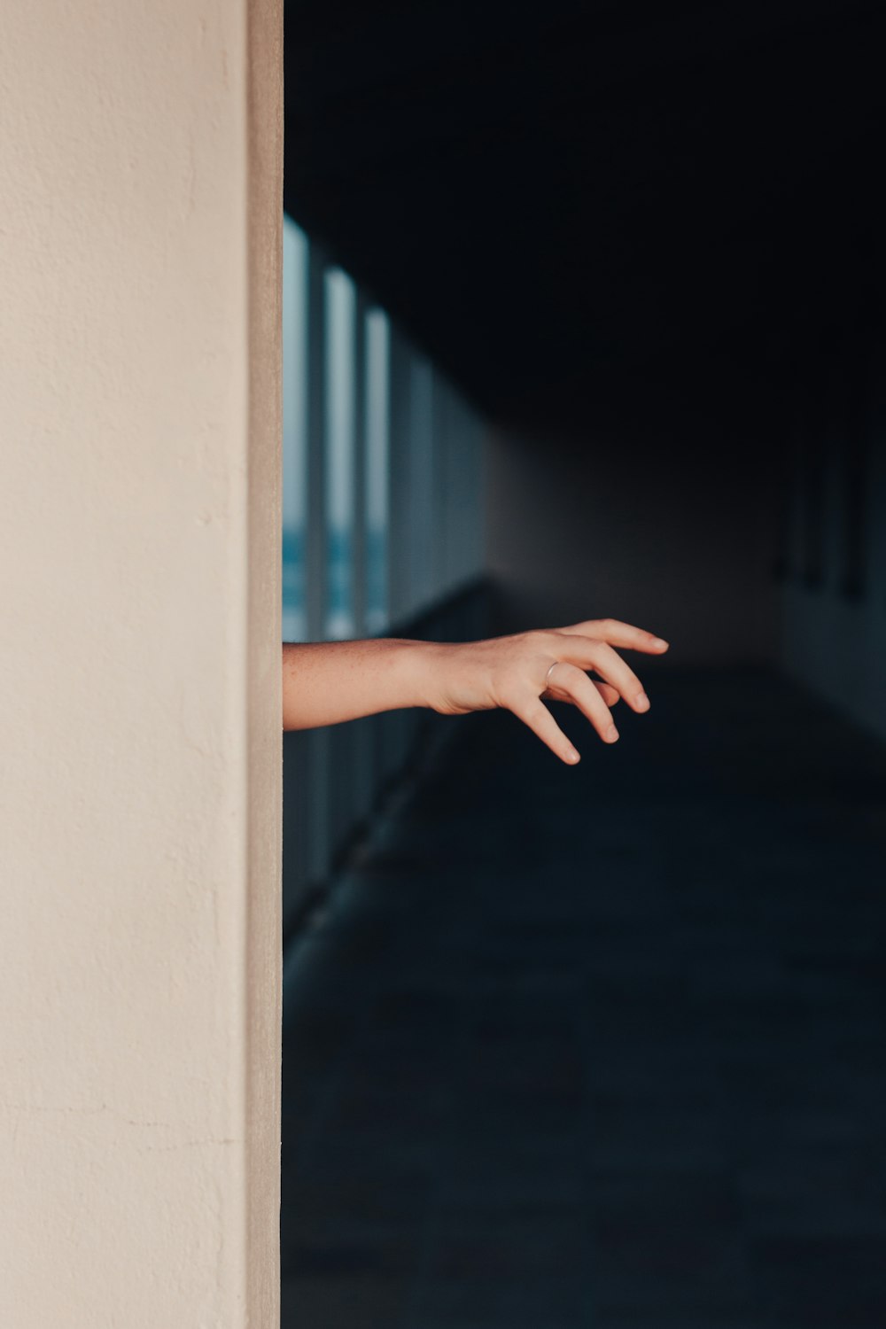 une main sortant d’une porte dans un couloir