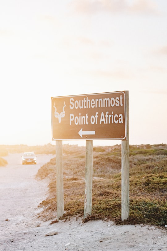 Southermost Point of Africa road sign and white vehicle on road during daytime in Agulhas National Park South Africa