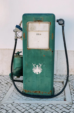 Side view of a restored gas pump showcasing intricate mechanical parts and aged patina.