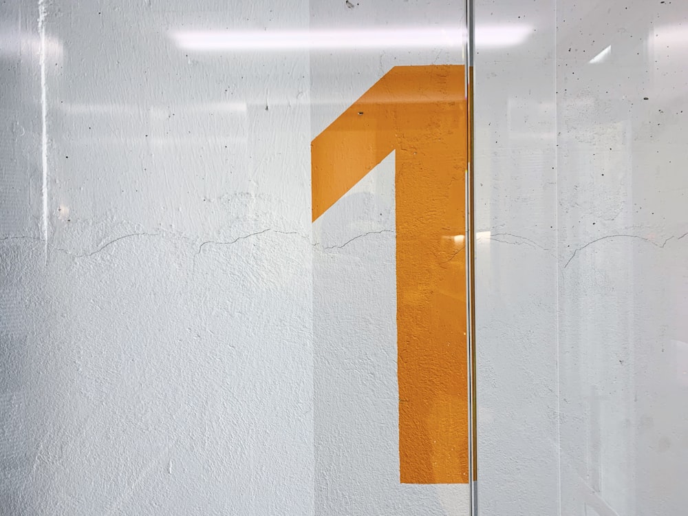 a white wall with a yellow number on it