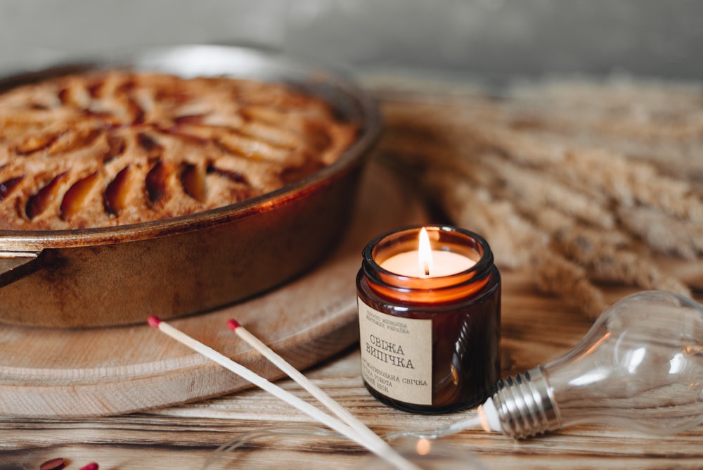 lit candle beside baked pie