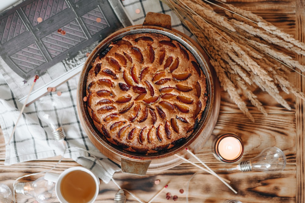 baked cake near brown wheat, clear light bulb, and tea in white ceramic teacup