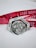 A silver medal with an intricate design featuring figures and the inscription 'KYW CITY MARATHON' and '21,0975 KM'. The medal rests on snow with a bright red ribbon that has text printed in white.