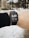 A person is wearing a smartwatch on their wrist, displaying a distance of 5.08 kilometers. The background is a snowy outdoor setting with some trees and buildings visible.