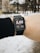 A person is wearing a smartwatch on their wrist, displaying a distance of 5.08 kilometers. The background is a snowy outdoor setting with some trees and buildings visible.