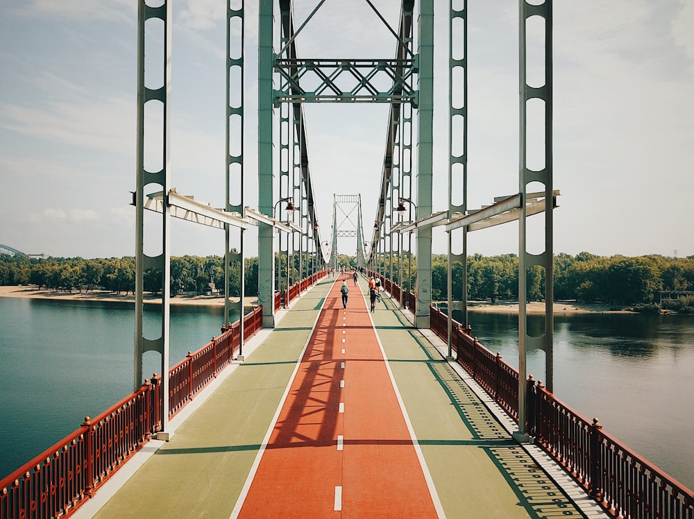 people walking along an iron bridge during daytime
