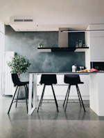 Minimalist kitchen featuring sleek black countertops and bold red accents.