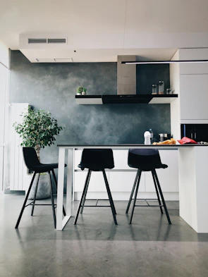 Minimalist kitchen featuring sleek black countertops and bold red accents.