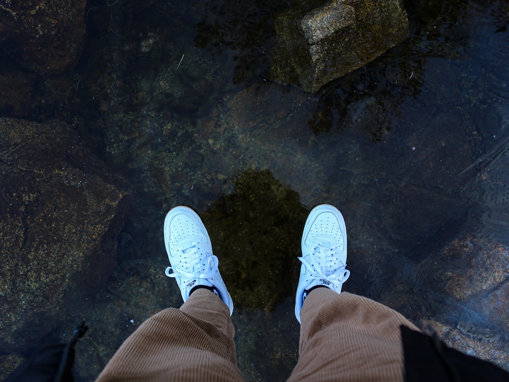 man wearing pair of white low-top sneakers