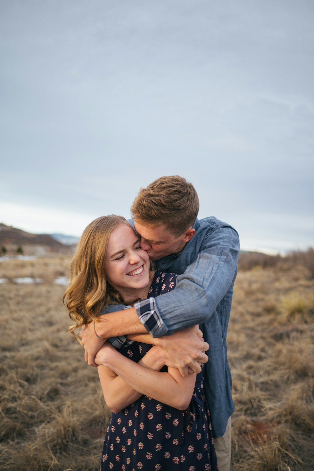 man kissing the woman wearing blue polka-dot dress