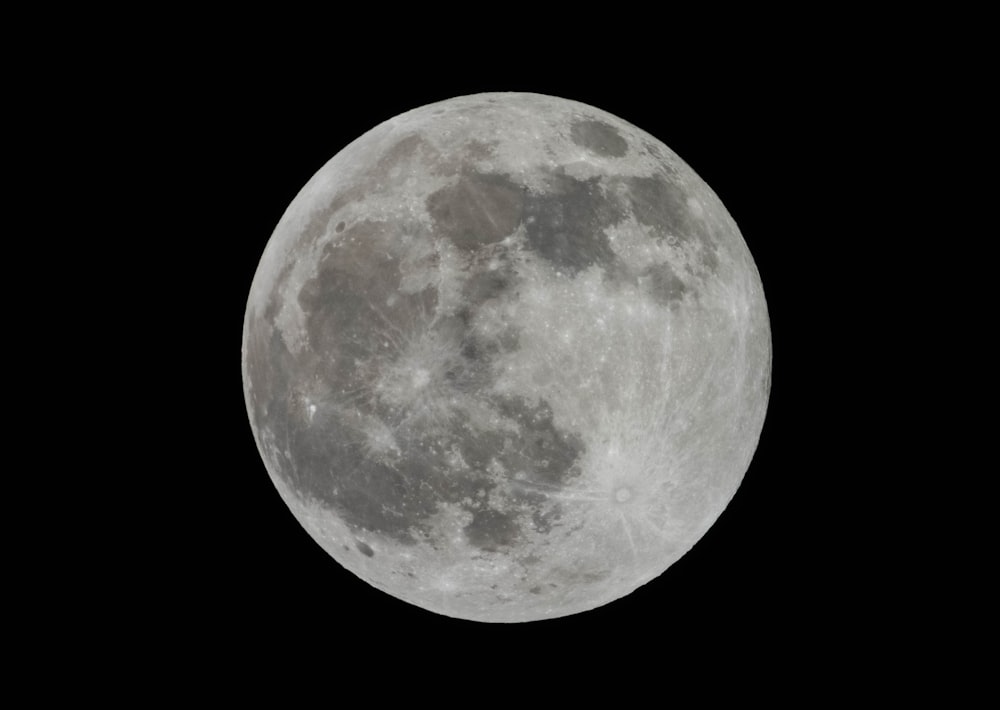 a full moon is seen in the dark sky