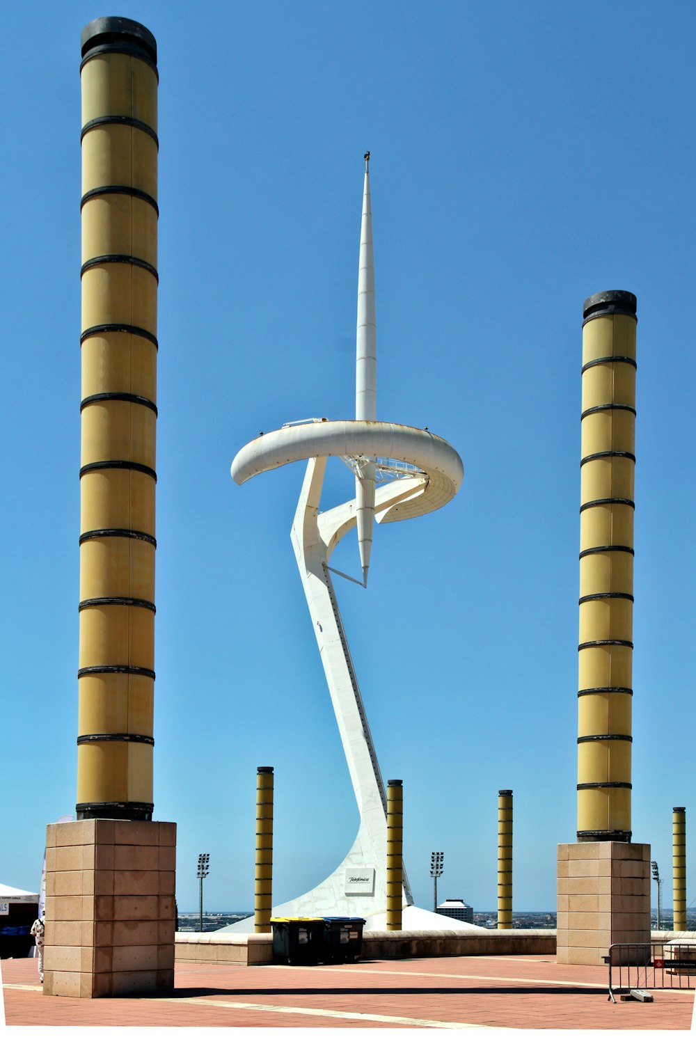 a tall white sculpture sitting next to two tall yellow pillars