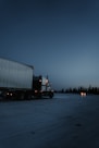 white and black freight truck traveling on road