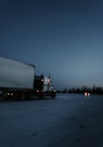 white and black freight truck traveling on road