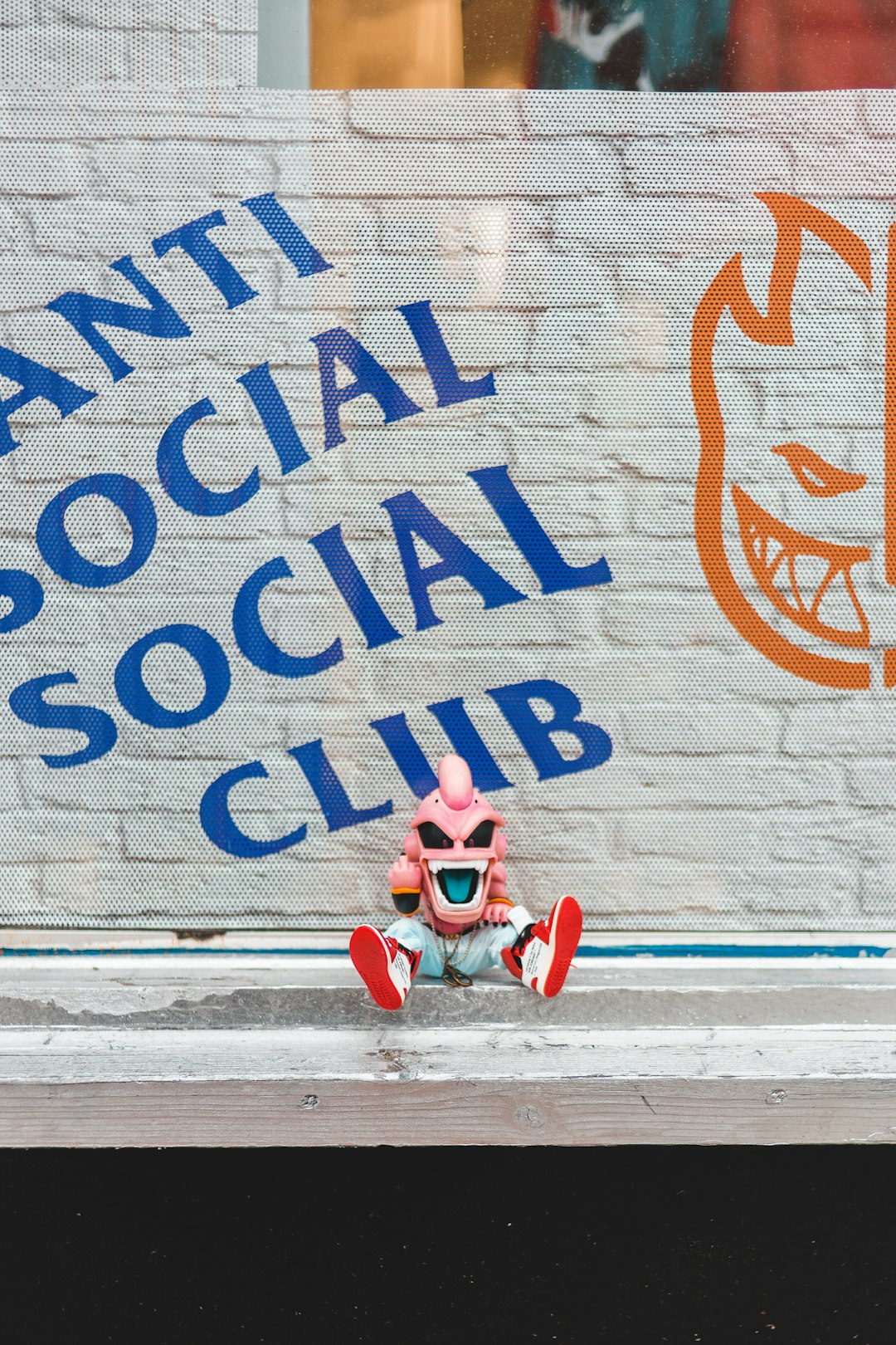 Kid Bu plush toy on sidewalk near Anti Social Social Club graffiti art