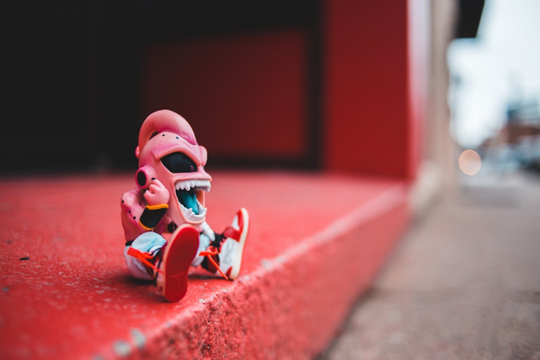 pink and white action figure on pavement