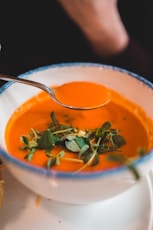 spoon of soup above bowl of soup