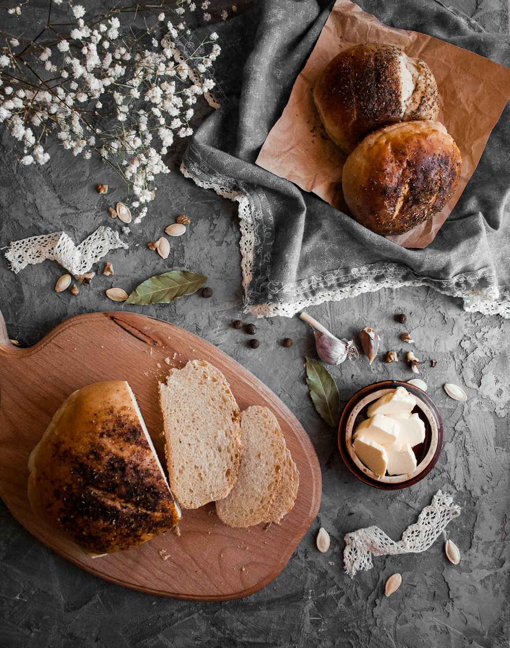 brown bread on grey textile near white flower