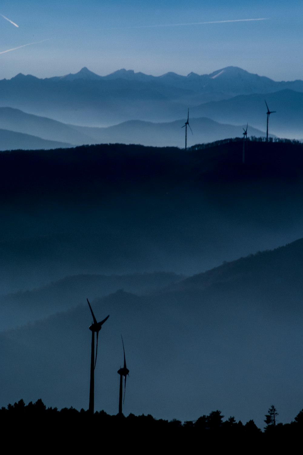 wind turbine overlooking mountain ridge