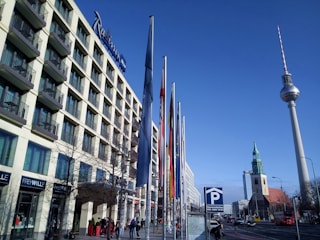 A city hall building with flags waving under a bright sky.